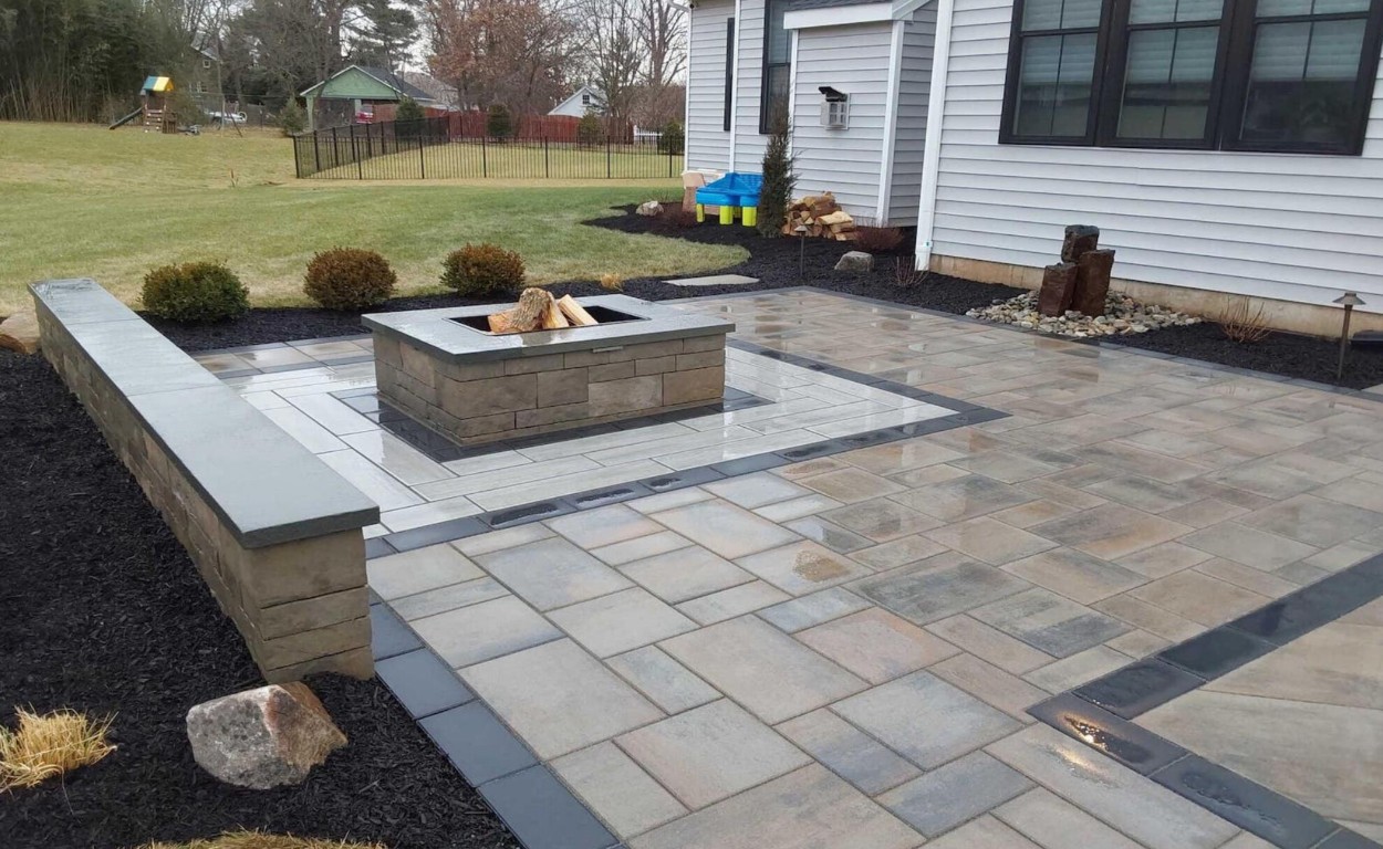 Custom concrete patio with fire pit and decorative pavers in Land O Lakes backyard